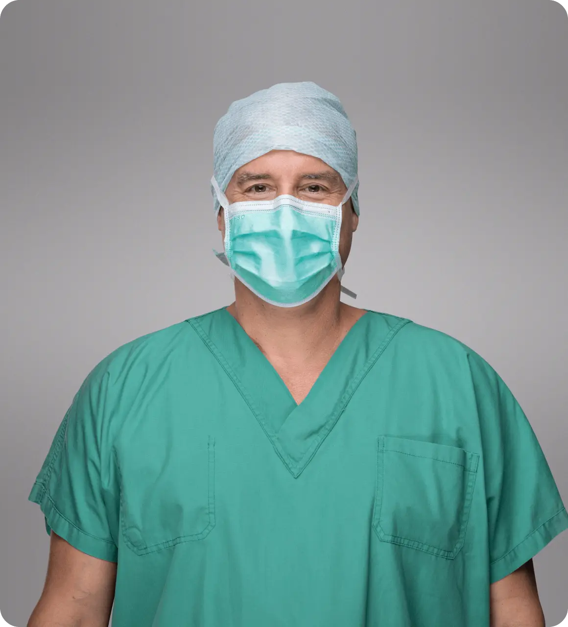 Dr Straka mit medizinischer Maske und Haarschutz im Portrait Bild